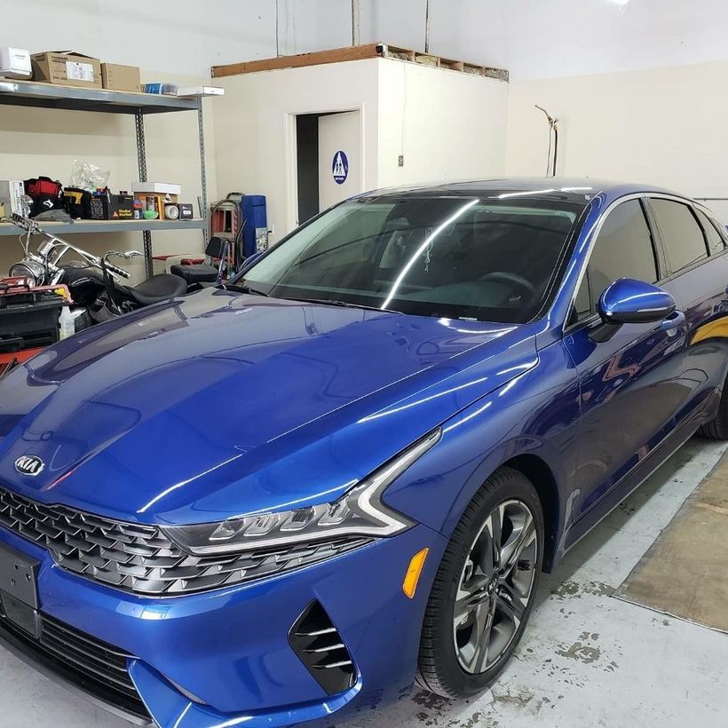 Blue Kia K5 in the bay after a full ceramic tint
