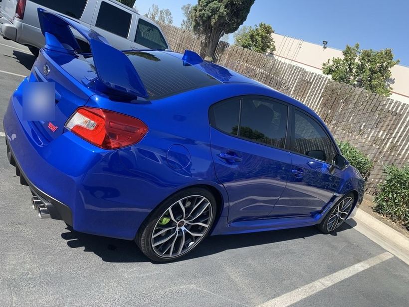 Blue Subaru WRX STI with tinted windows, rear three-quarter
